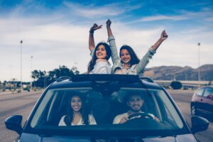 Conductores adolescentes asomándose por un techo solar