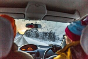 Two people driving in the snow